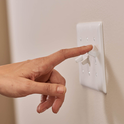 person turning off a light switch
